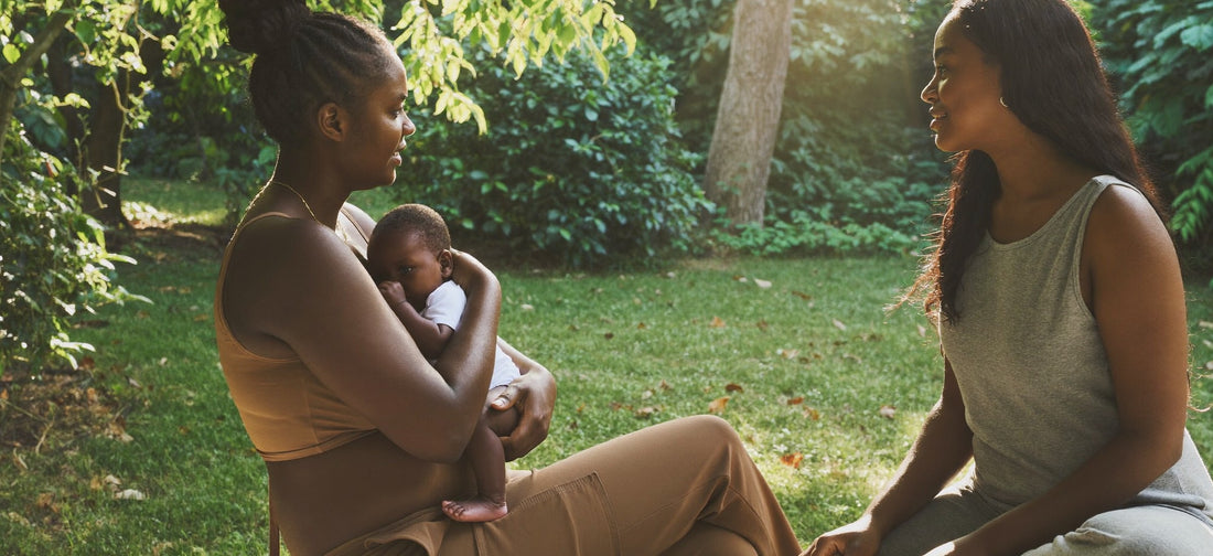 Two South African women talking outdoors, representing supportive postpartum conversations