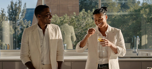 Two young adult colleagues sharing a relaxed conversation during an office kitchen break