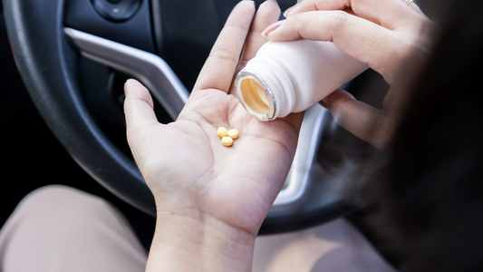 Person holding antihistamine pills in hand inside car highlighting antihistamines side effects while driving riesgo
