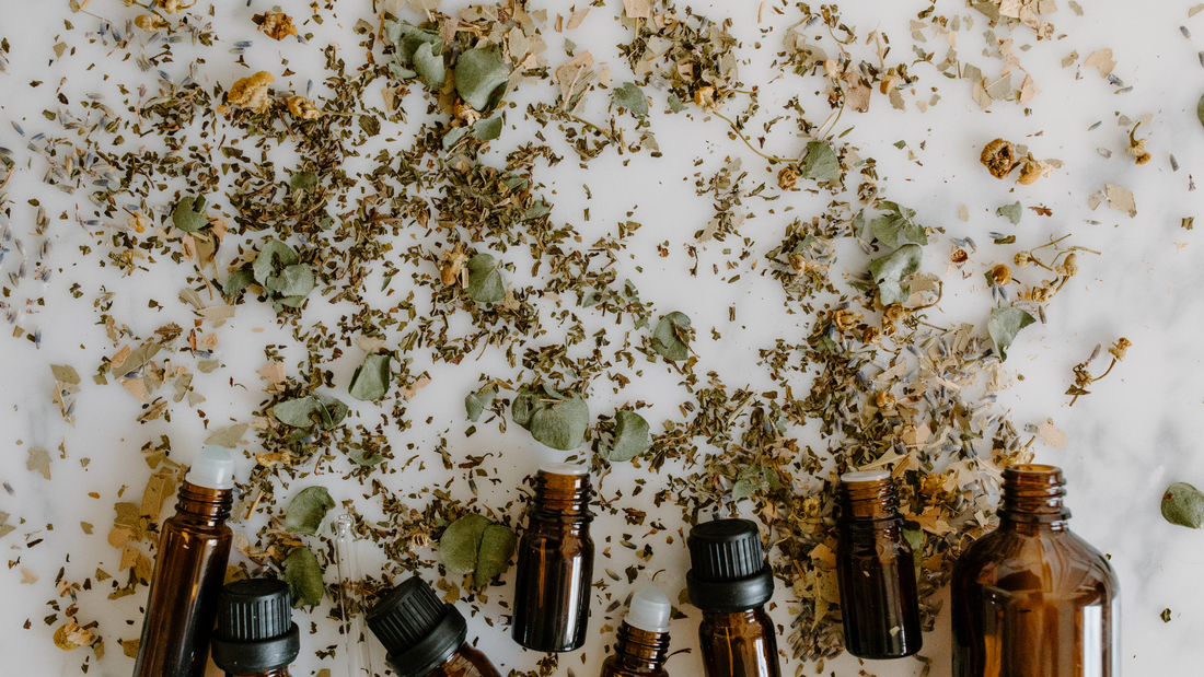 Brown glass bottles with dried herbs scattered around, natural remedies for endometriosis treatment.