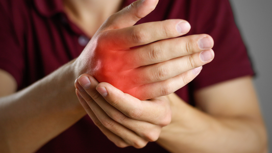 person holding wrist with red highlight indicating arthritis pain types of arthritis