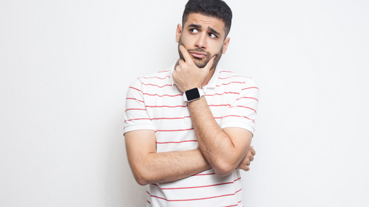 young man with hand on chin looking worried about digestive problems