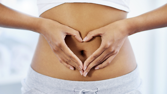 Close-up of a person forming a heart shape with hands over healthy stomach area to restore healthy gut bacteria