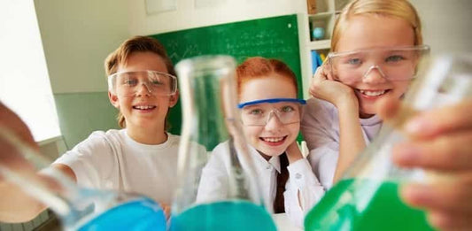 happy children wearing safety goggles conducting science experiments with colorful liquids in laboratory glassware
