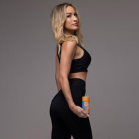 fit woman in black activewear holding GutSlim Probiotics fat burner supplement for gut health and weight loss