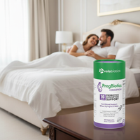 PregBiotics Conception probiotic supplement bottle on bedside table with couple in background, conception support vitamins and minerals for healthy pregnancy preparation